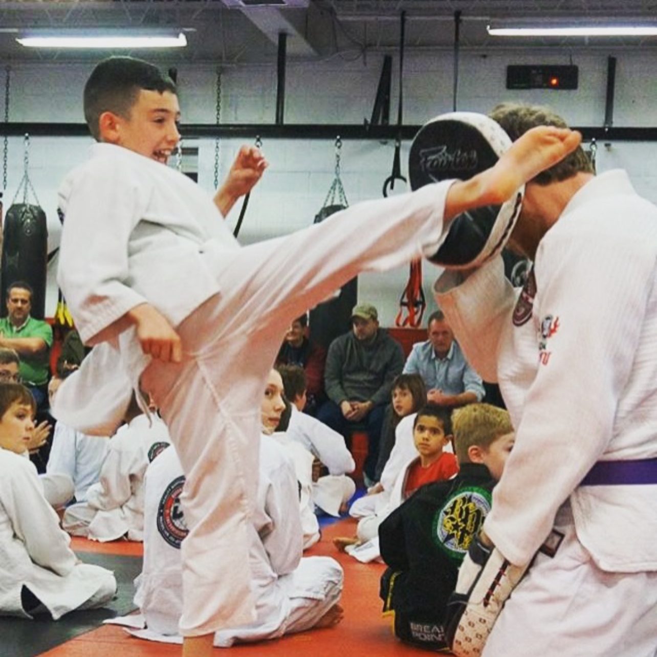 A youth student kicks the pad